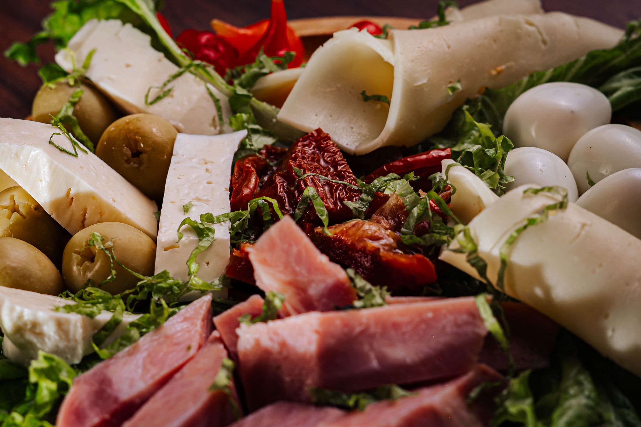 An antipasto spread with cold cuts, mozzarella, cheese and olives